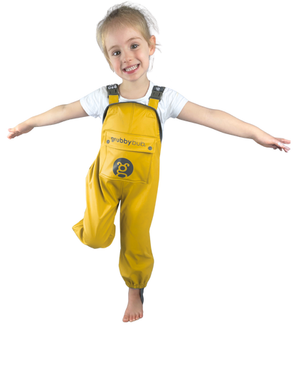 Child wearing yellow waterproof rain pant overalls on a white background